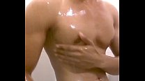Handsome man showering and showing off his body
