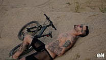 Homem tatuado de corpo inteiro em tiras de bicicleta e mostrando o pau do prepúcio sem cortes