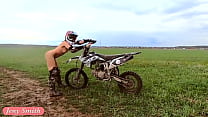 Mujer desnuda montando una moto de cross