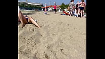 La moglie espone la figa sotto le mutandine su una spiaggia pubblica