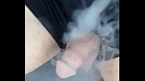 Blowing smoke at his cock