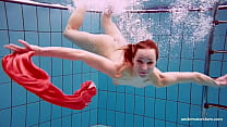 裸で泳いでいる愛らしいブルネットの若い女性