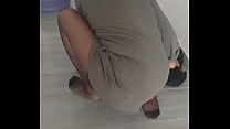 Зрелая женщина в нейлоновых чулках в тюрбане вытирает полы