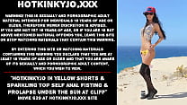 Hotkinkyjo in gelben Shorts und glitzerndem Top, Selbstanalfisting und Prolaps unter der Sonne an einer Klippe